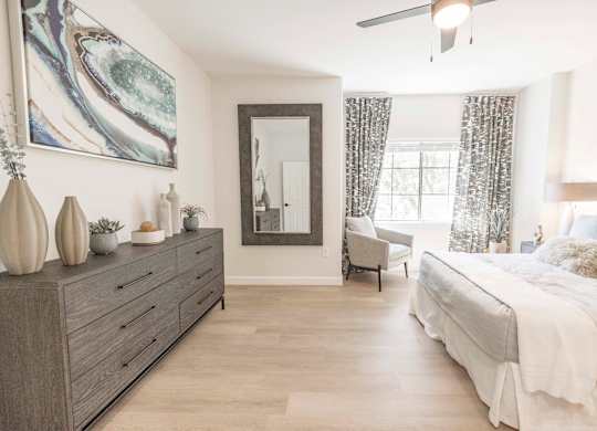 A bedroom with a large bed, a dresser, and a mirror.