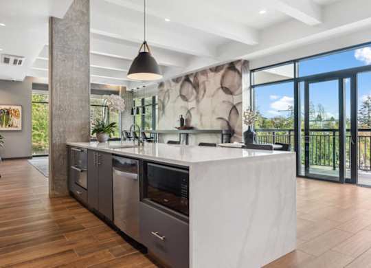 A modern kitchen with a large island and a view of the outdoors.