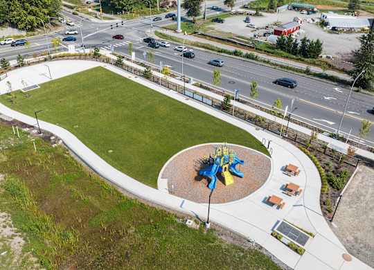 A playground with a blue and yellow structure in the center of a green field.