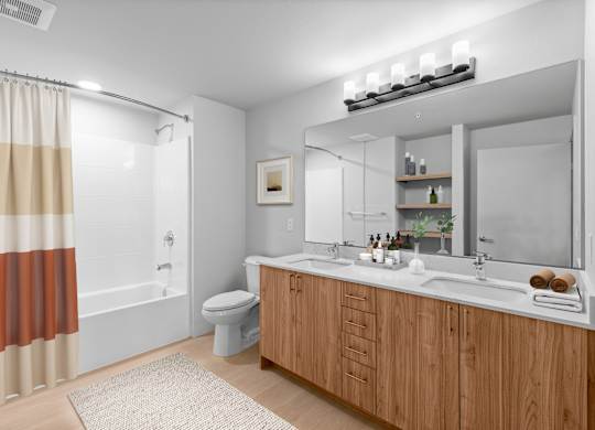 A modern bathroom with a wooden vanity and a large mirror.