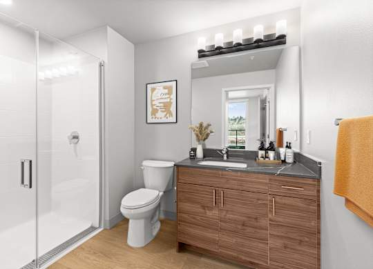 A bathroom with a toilet, sink, and mirror.
