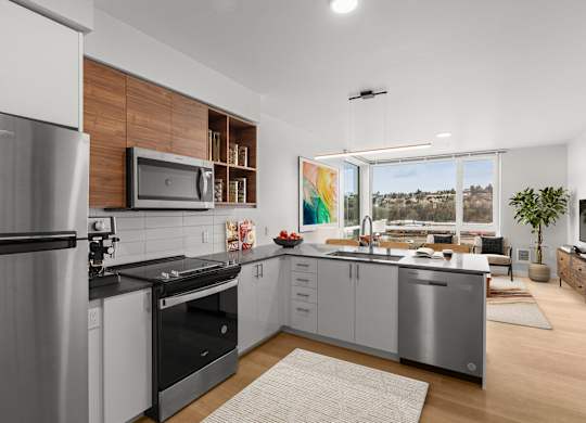A modern kitchen with a stainless steel refrigerator and a microwave above the stove.