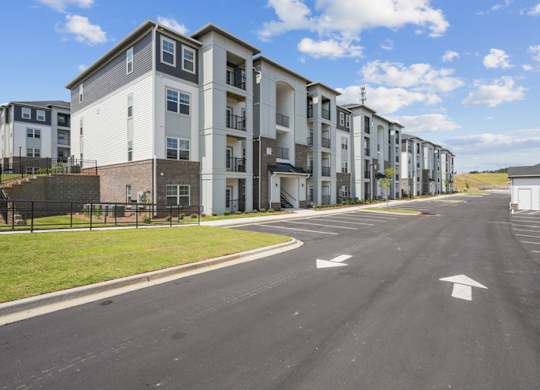 Apartment complex with a road in front of it.