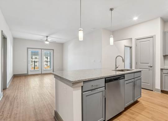 A kitchen with a large island and stainless steel appliances.