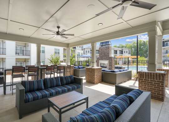 A patio with a black sofa and a table.