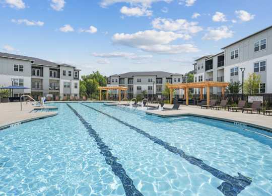 A large swimming pool in front of apartment buildings.