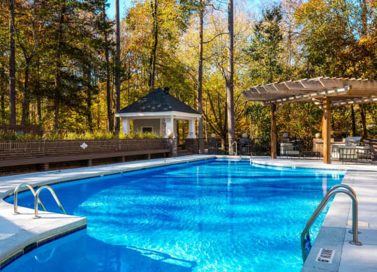 a swimming pool with a gazebo in the background