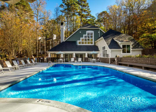 a swimming pool with a house in the background