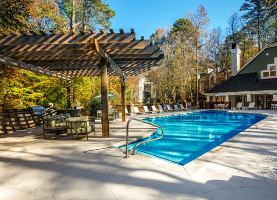 a swimming pool with chairs and umbrellas around it