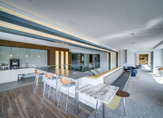 A modern kitchen with a long table and chairs.