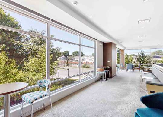 A sunny day in a spacious room with a view of the street and trees outside.