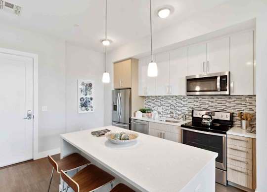 A kitchen with a white table and a white fridge.