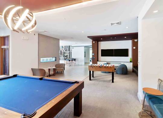 A room with a pool table and a couch.