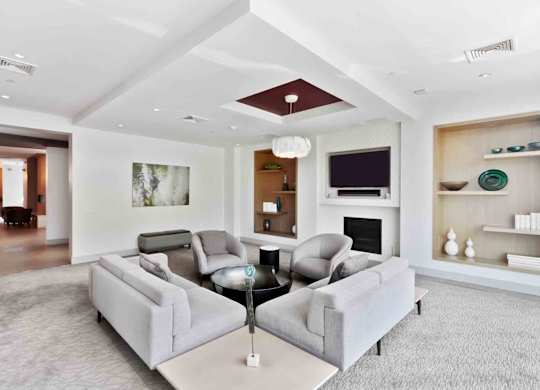 A living room with a grey couch and a fireplace.