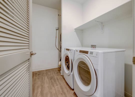 a washer and dryer in a laundry room with a white closet