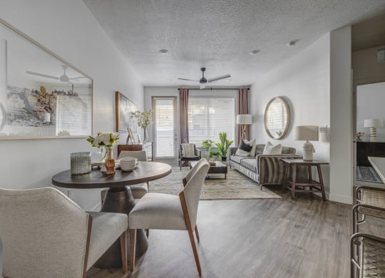 a living room and dining room with a table and chairs
