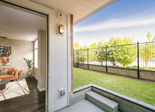 A balcony with a black railing and a small garden area.