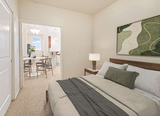 A bedroom with a large bed and a painting on the wall.