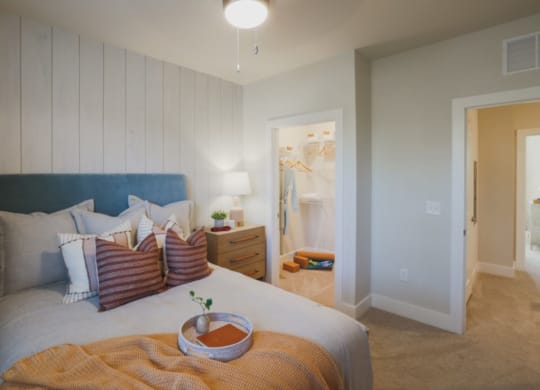 a bedroom with a large bed and a bathroom in the background