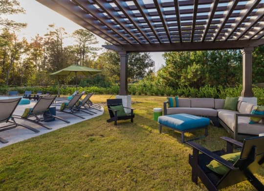 a lounge area with a pergola in a backyard