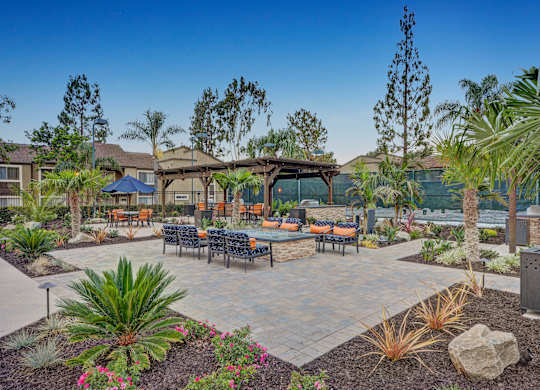 A patio with a table and chairs surrounded by plants.