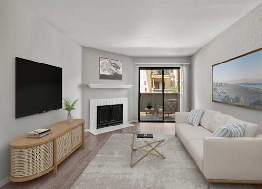 A living room with a white couch, a fireplace, and a painting on the wall.