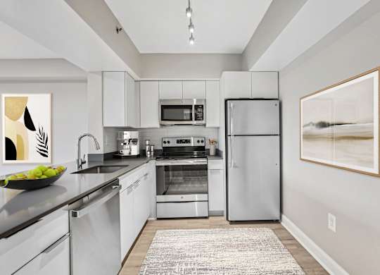 a modern kitchen with stainless steel appliances and white cabinets