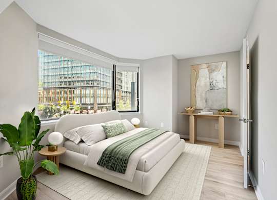 a bedroom with a white bed and a large window