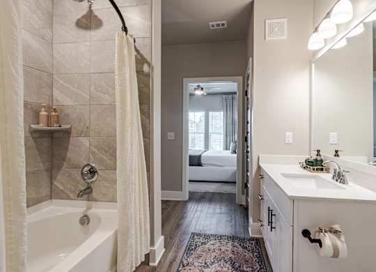 A bathroom with a white tub and a white sink.