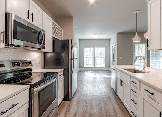 A kitchen with black appliances and white cabinets.
