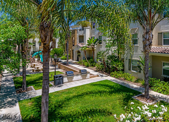 A sunny day in a residential area with apartment buildings and a well-kept garden.