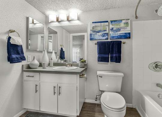 A white bathroom with a white toilet, sink, and bathtub.