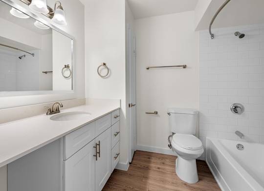 A white bathroom with a toilet, sink, and mirror.