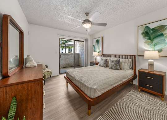 A bedroom with a bed, dresser, and mirror.