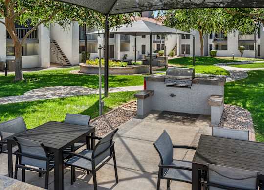 A patio with a table and chairs is set up under a canopy.