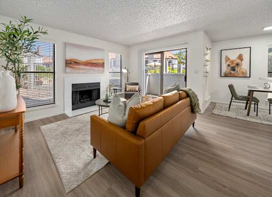 A living room with a brown couch and a fireplace.