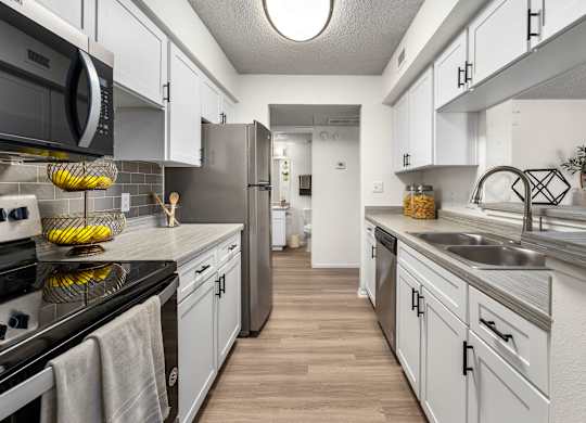A kitchen with white cabinets and a black stove top oven.