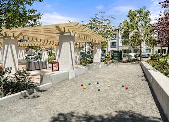 A playground with a wooden pergola and concrete ground.