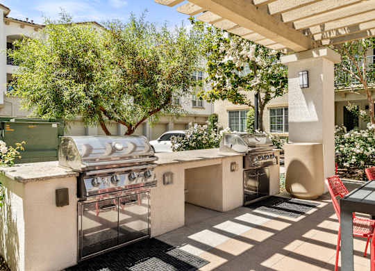 A patio with a grill and a table.