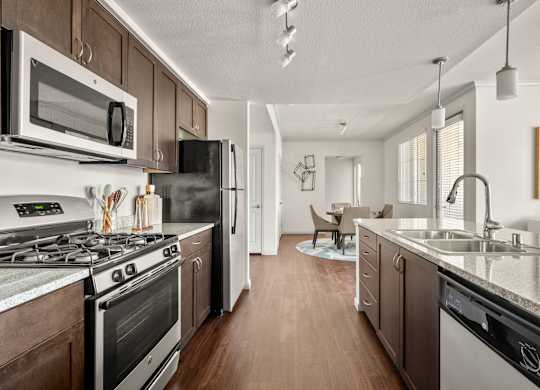 A modern kitchen with dark wood cabinets and stainless steel appliances.