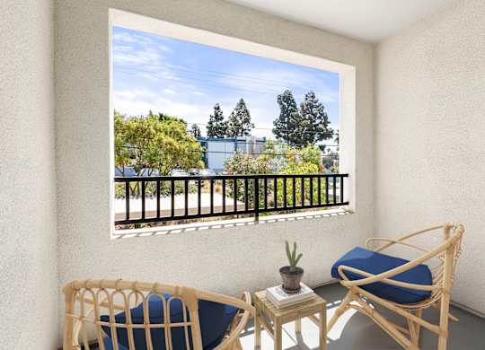A personal patio with lounge chairs and a table.
