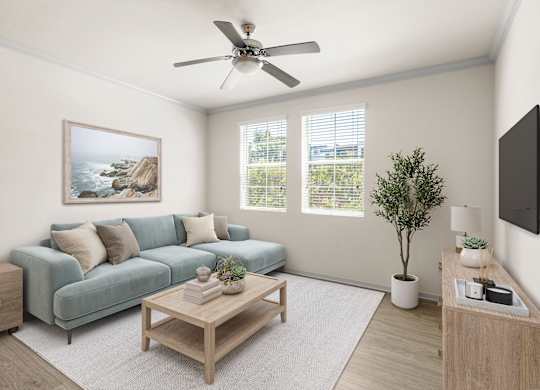 A spacious living room with a couch, coffee table, windows and ceiling fan.