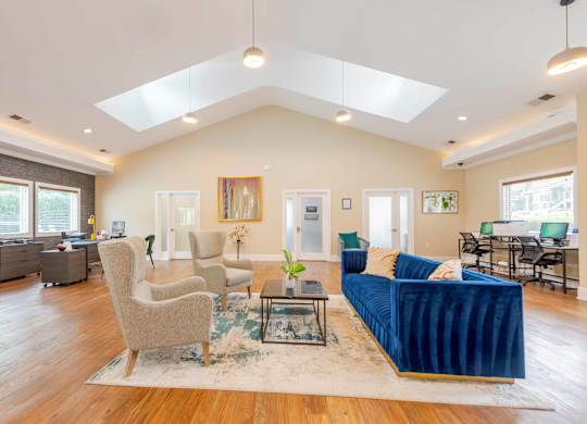 the clubhouse with a blue couch and two tan chairs
