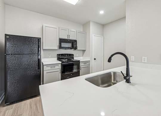 A kitchen with a black refrigerator, stove, and oven at Clear Creek Meadows Apartments, Copperas Cove