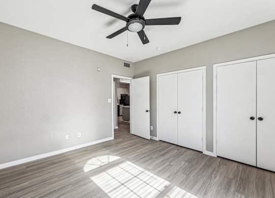 A room with a ceiling fan and three white doors at Clear Creek Meadows Apartments, Apartments, Copperas Cove, TX
