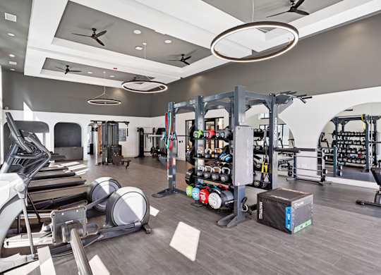 A spacious gym with treadmills, weights, and other exercise equipment.