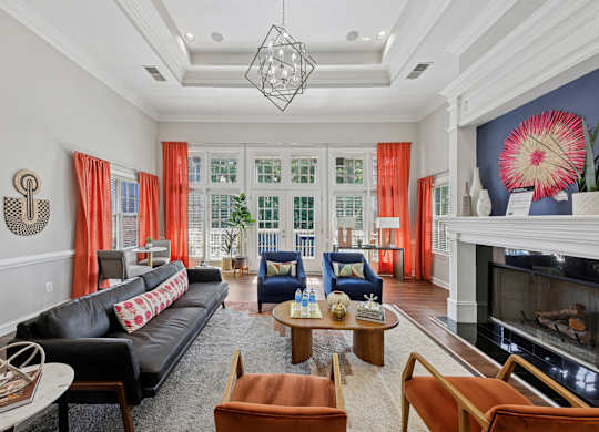 A living room with a black couch and a fireplace.
