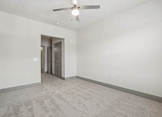 A room with a ceiling fan and a carpeted floor.