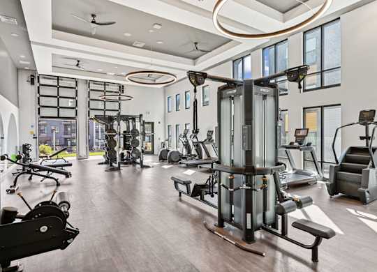 A spacious gym with a variety of equipment including treadmills, weights, and exercise machines.