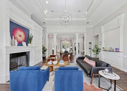 A living room with a fireplace and blue chairs.